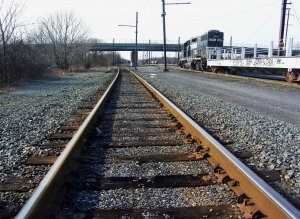 Parked-Rail-Cars-Next-To-Empty-Train-Tracks-In-Rail-Yard.jpg